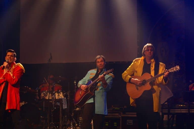 Bühnenaufnahme der Coverband Abenteuerland bei einem Live-Event, mit Musikern in bunten Kostümen und Gitarren, die für unvergessliche Partystimmung sorgen.