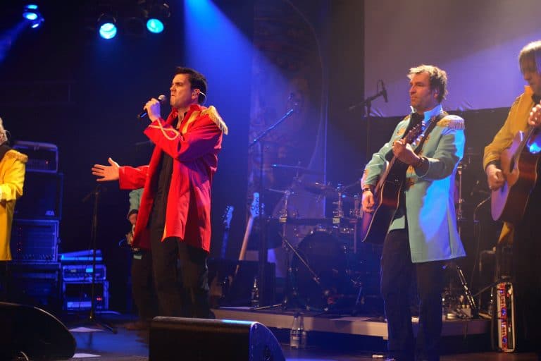 Feuriges Coverband auf der Bühne bei einem Abenteuerland-Event, mit farbenfrohem Bühnenbild, Live-Musik und mitreißender Performance für unvergessliche Momente.