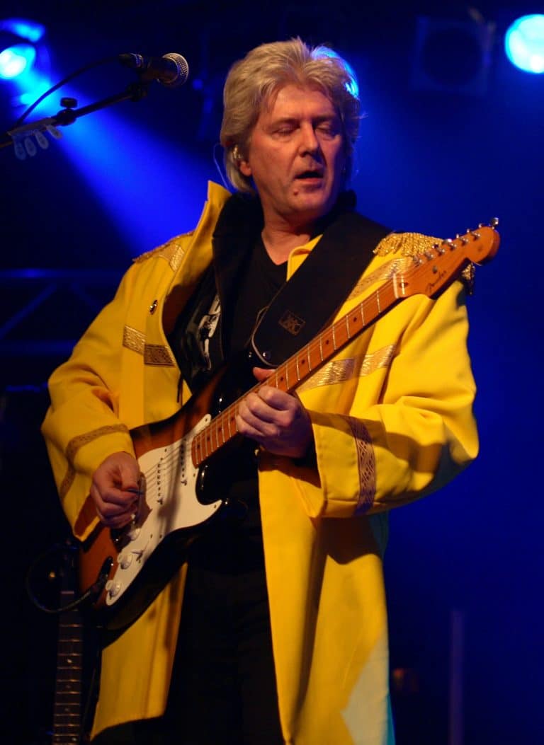 Fame: Abenteuerland Coverband, Musiker auf Bühne, Gitarrist in gelbem Jackett, Live-Musik, Rock-Events, professioneller Musikauftritt.