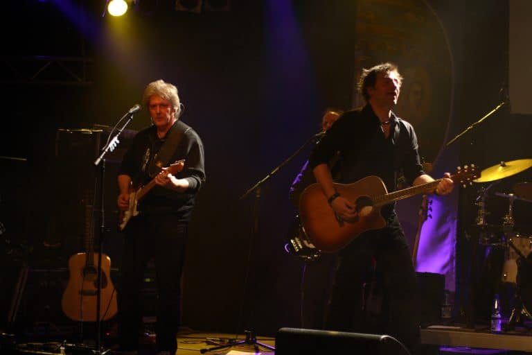 Gelungene Abenteuerland Coverband Performance bei einem Konzert, Musiker mit Gitarren auf der Bühne, stimmungsvolle Live-Musik, professionelle Veranstaltung, begeistert Publikum.