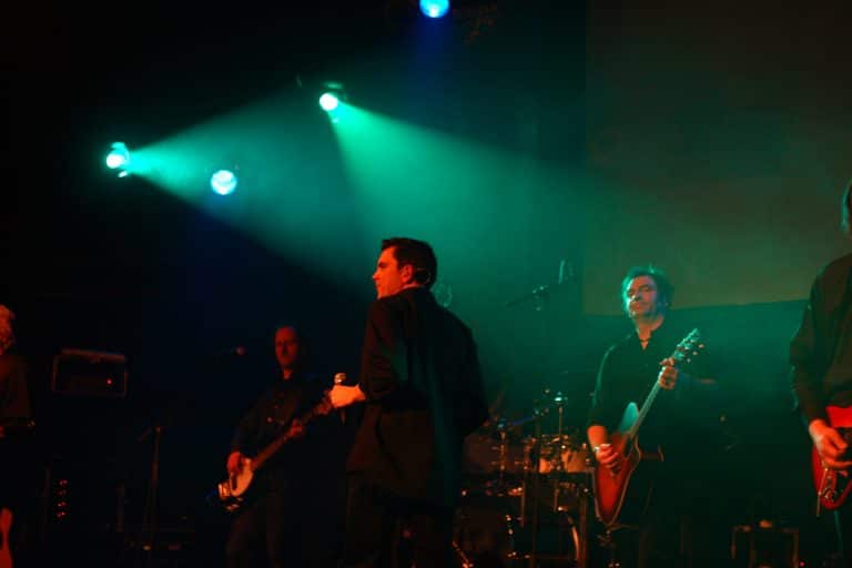 Farbenfrohe Bühnenbeleuchtung bei einem Auftritt im Abenteuerland, Live-Band spielt auf einer professionellen Konzertbühne.