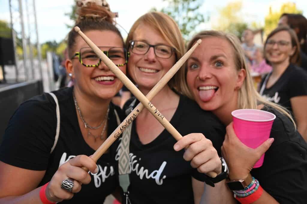Fröhliche Bandmitglieder beim Abenteuerland-Festival, die Spaß haben und feiern.